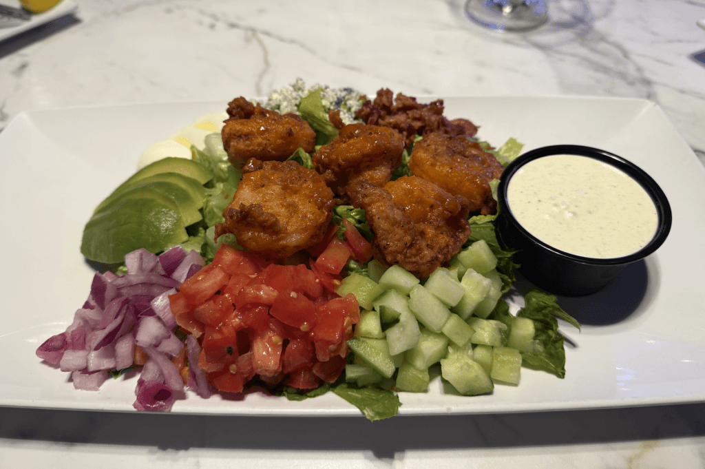 Buffalo shrimp salad with lightly breaded shrimp, avocado, bacon, bleu cheese, and house dressing at Fish Tale Grill Cape Coral.