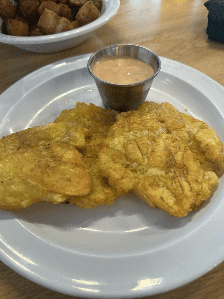 Crispy golden tostones served with pink sauce, a classic Puerto Rican cuisine side dish.