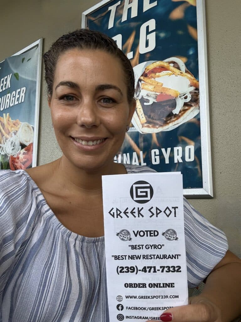 Front and back of The Greek Spot newspaper-style menu inside the restaurant.