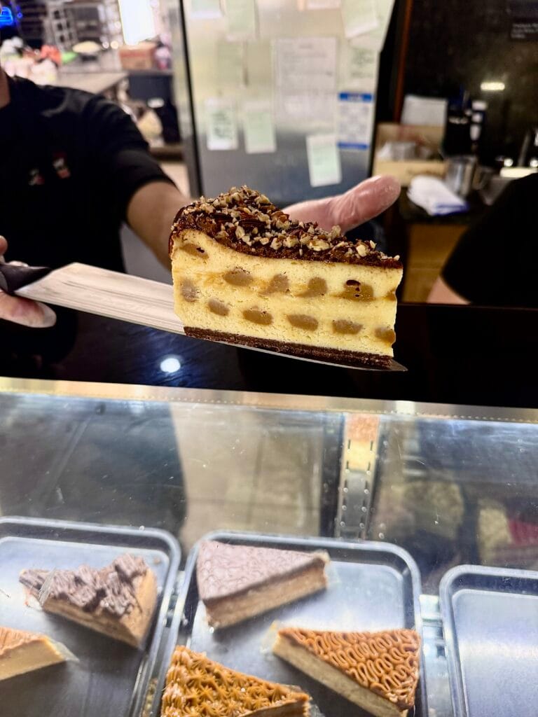 Rich cheesecake slice served at Amore Italian Market And Bakery pastry counter.