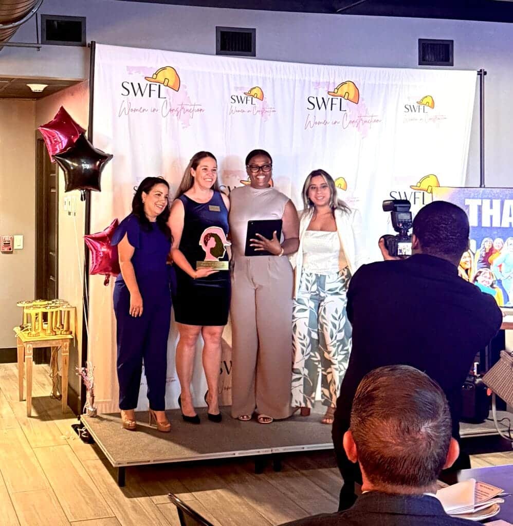 Women receiving recognition on stage during the SWFL Women in Construction Week awards ceremony.